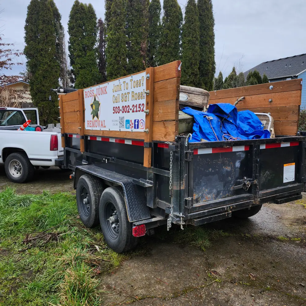 Loaded Ross Junk Removal dump trailer parked in a residential driveway in the Salem area
