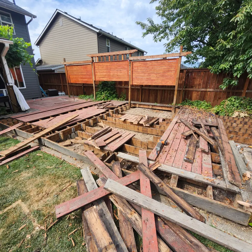 Before: old backyard deck boards removed and stacked for debris removal in Salem, OR