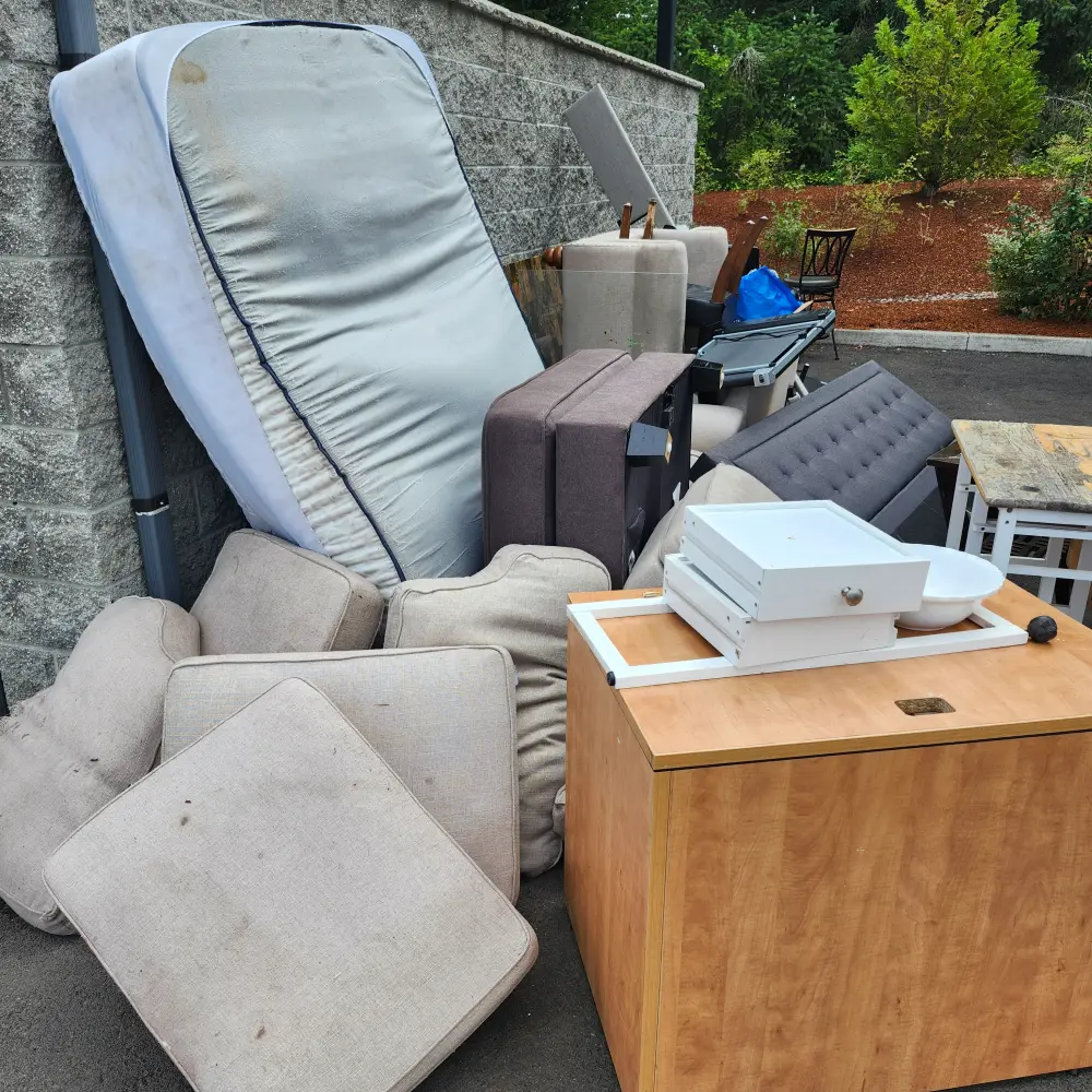Curbside mattresses, cushions, and furniture staged for junk removal in the Salem area