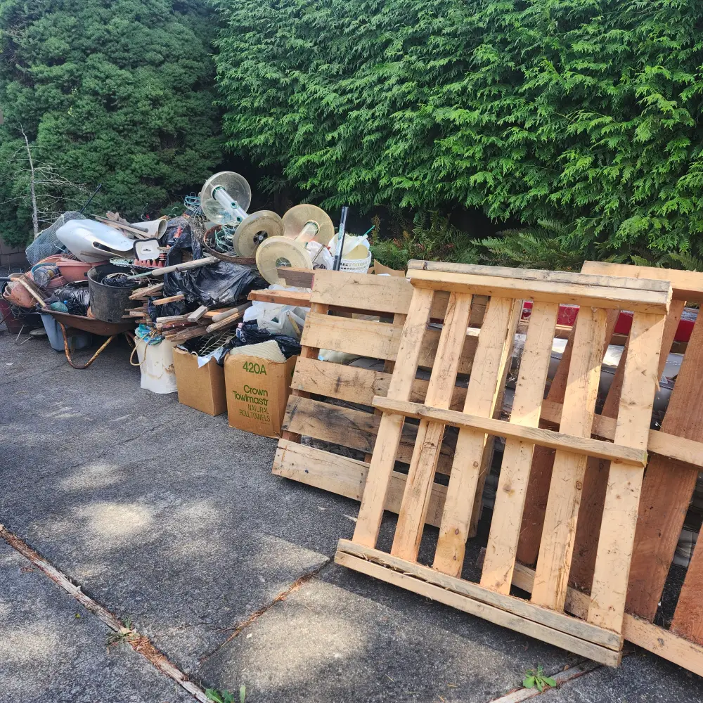 Wood pallets and scrap metal piled curbside in West Salem, OR for haul-away