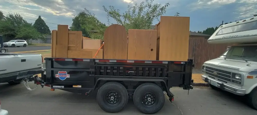 Dump trailer loaded with old wood cabinets and furniture hauled from Orchard Heights