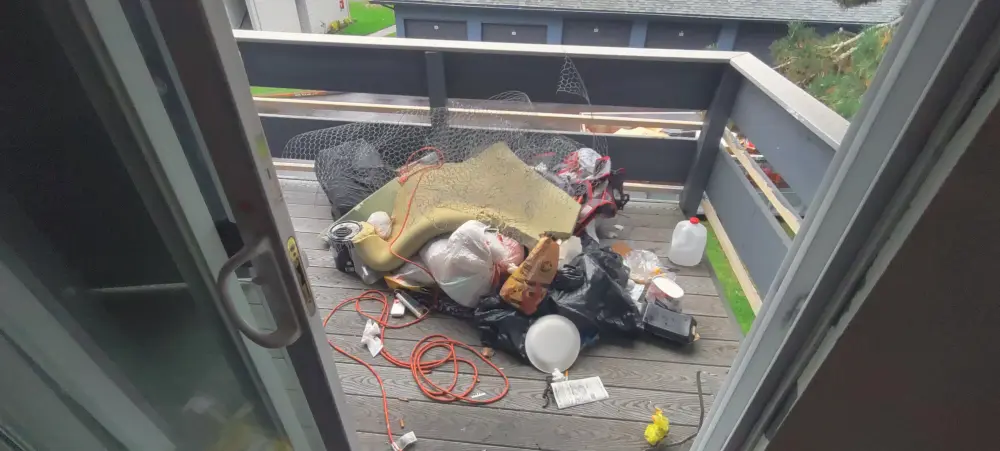 Old carpet and bagged trash removed from a backyard deck in Glen Creek, OR